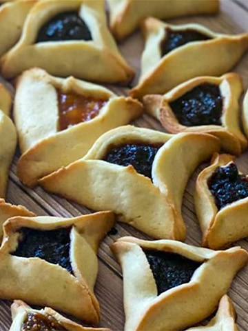 Hamantaschen spread out on a table.