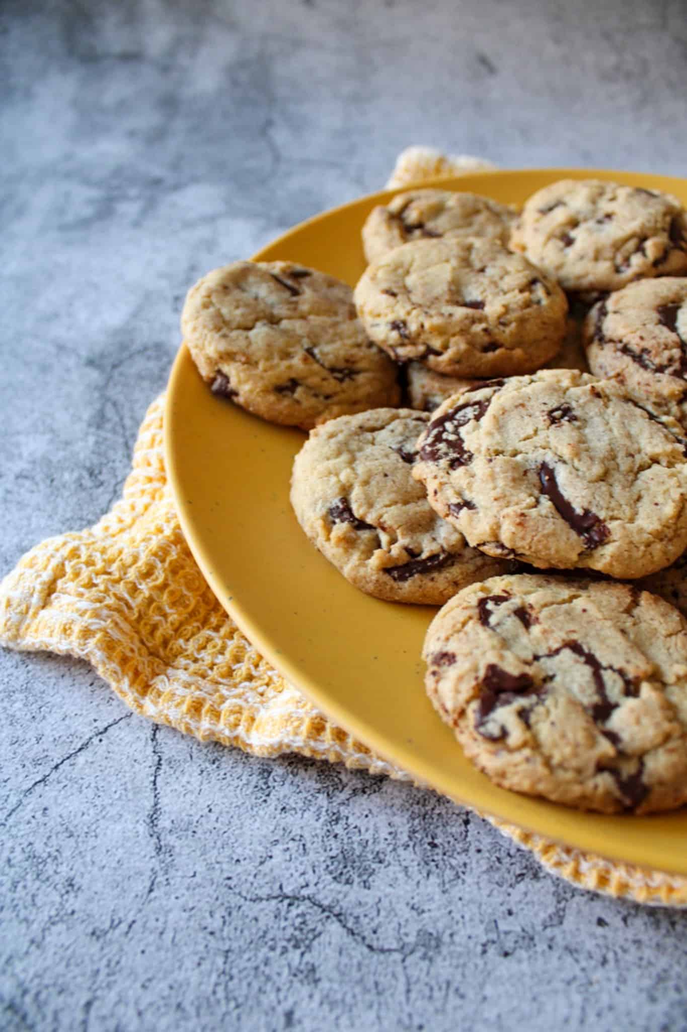 Chocolate chip cookies on a yellow plate. 