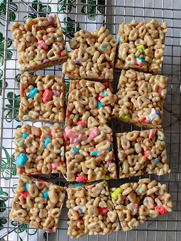 Lucky Charms Rice Krispie Treats cut and sitting on a cooling rack.