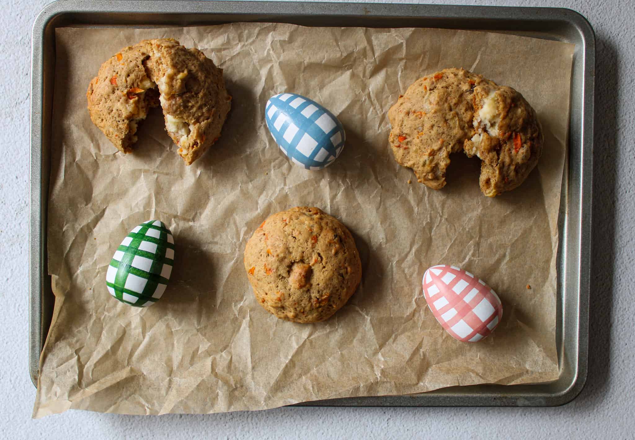 Stuffed carrot cake cookies with Easter eggs on a parchment paper. 