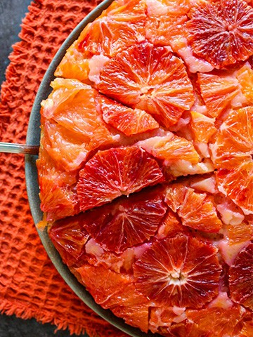 A slice of winter citrus upside down cake being sliced.