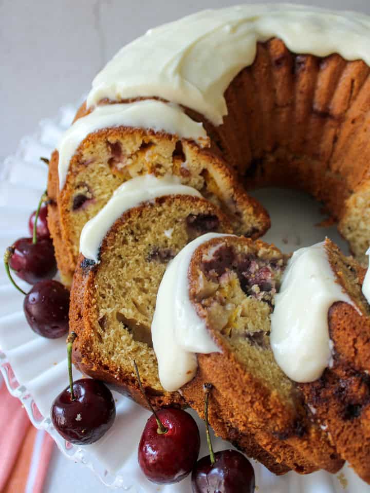 Stone fruit cake with cherries and nectarines slices on a cake plate.