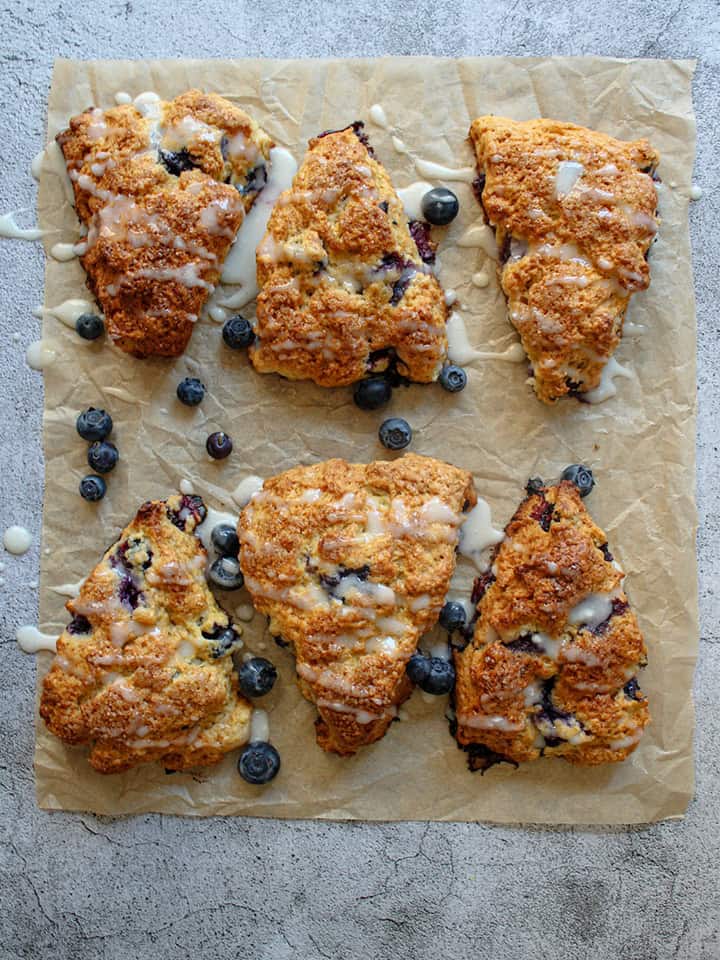 Lemon blueberry scones on a piece of parchment paper.