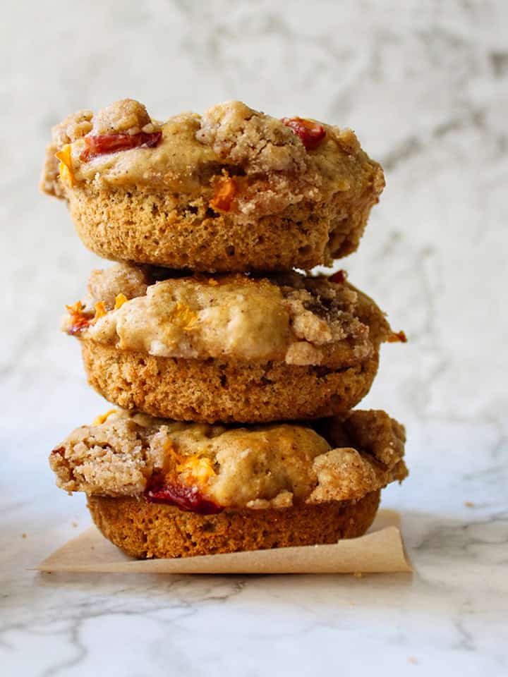 A stack of peach crumble donuts on top of each other.