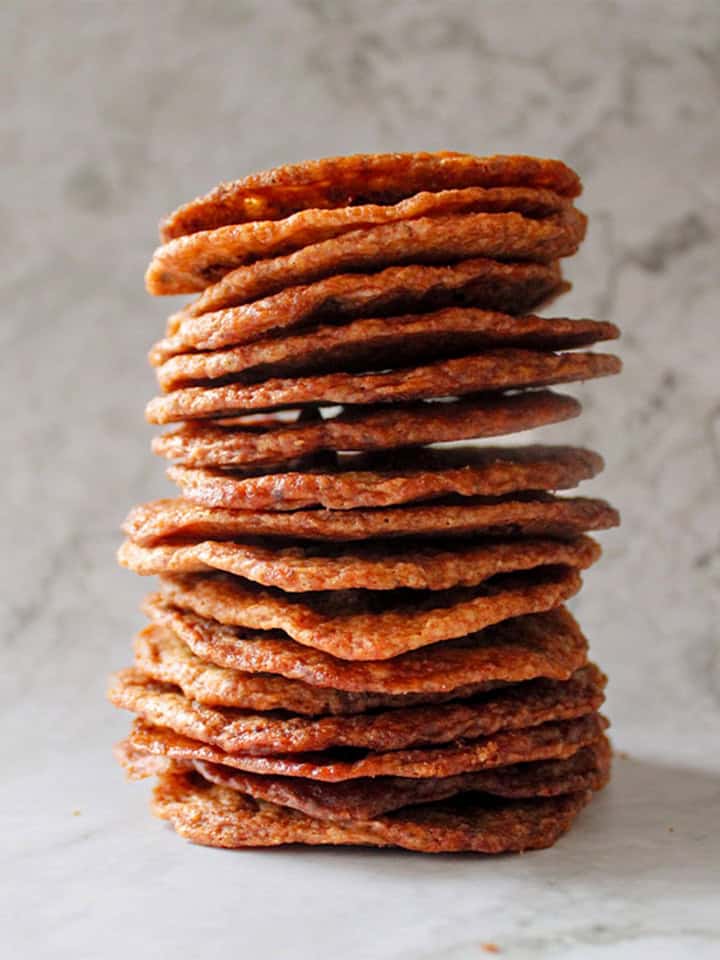 A stack of thin and crispy chocolate chip cookies.